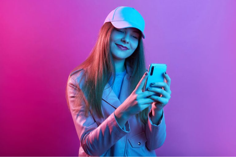 portrait-young-beautiful-fashionable-model-wearing-leather-baker-baseball-cap-holding-smart-phone-hands 1